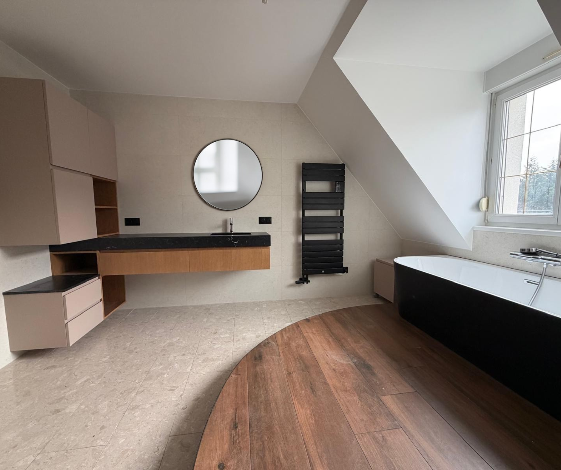 Meuble vasque suspendu sur mesure Le Square, design minimaliste et plan de toilette en pierre noire avec miroir rond, réalisation haut de gamme en Alsace.